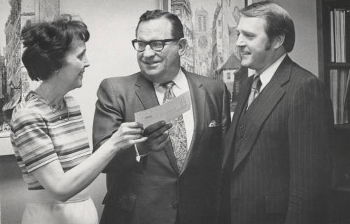 Dr. Miller Receives Check from Vivienne Gardner as Warren Summer Observes