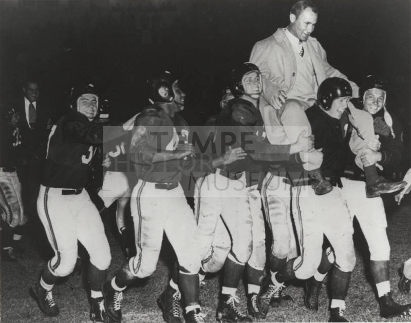 A Football Team Carrying a Coach