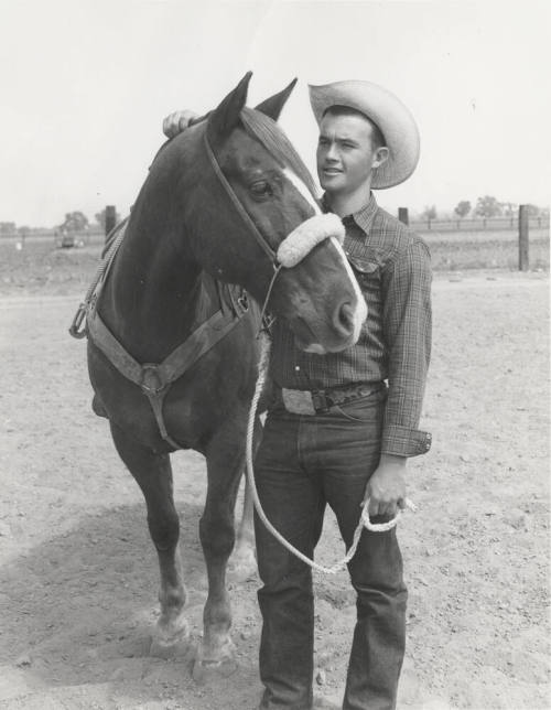 Cowboy Standing by Horse Holding Lead