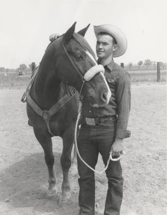 Cowboy Standing by Horse Holding Lead